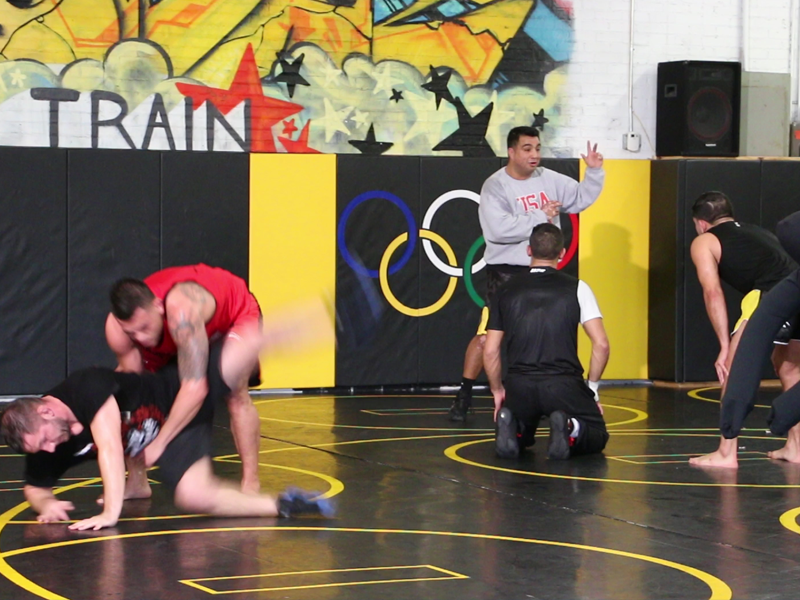 Coach Martinez instructing Sergio Pettis, with Anthony Pettis in foreground